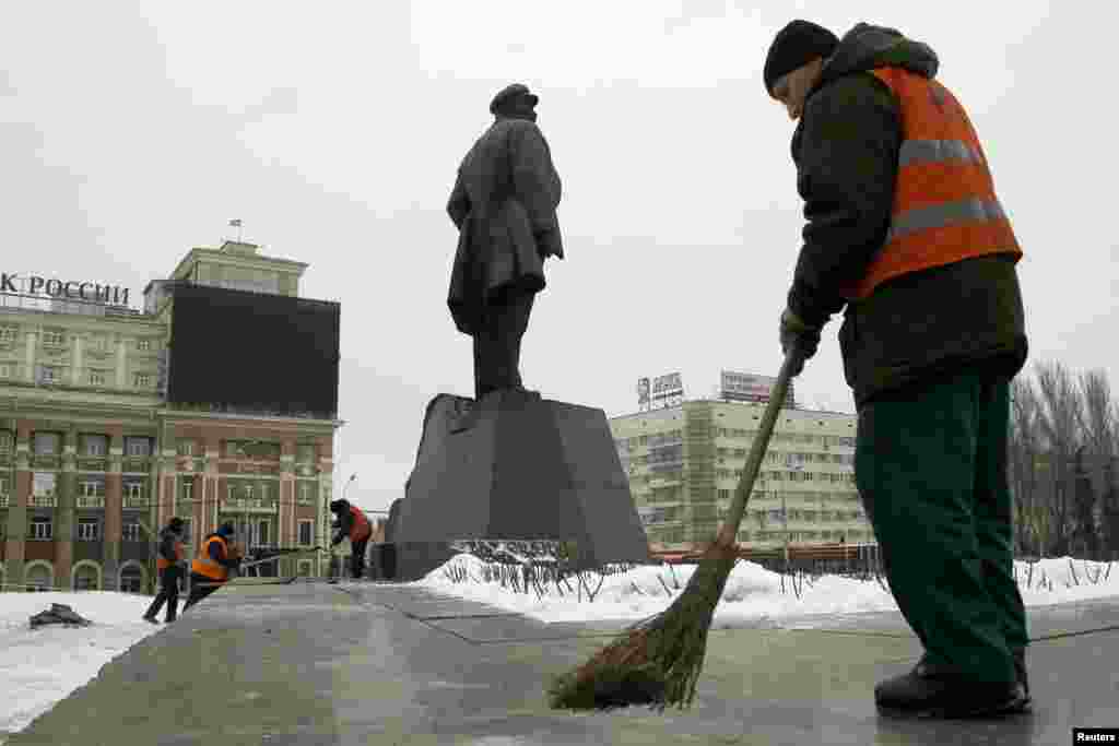 Працівники комунальних служб вичищають наслідки вибуху біля пам&#39;ятника Леніну у Донецьку. Внаслідок вибуху, що стався близько четвертої ранку 27 січня, була пошкоджена частина постаменту