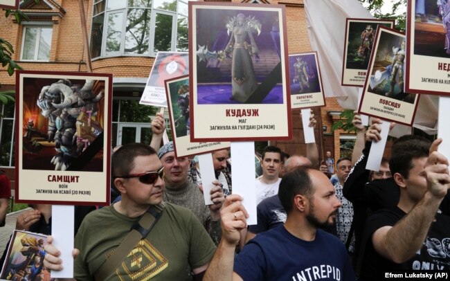 Активісти тримають зображення героїв комп'ютерних ігор на знак протесту проти акції «Безсмертний полк» 9 травня 2018 року у Києві