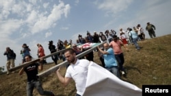 Protesters remove a border sign erected by Russian and Ossetian troops along Georgia's de-facto border with its breakaway region of South Ossetia in the village of Khurvaleti on July 14.