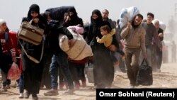 People walk with their belongings as they flee a rebel-held town in eastern Ghouta on March 15.