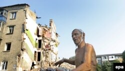 Viktor Stepanenko, 69 de ani, arătând ce a rămas din casa lui, în care și-a pierdut soția, în urma unei rachete Grad trase de forțele guvernamentale în orașul Snijne, 22 iulie, 2014.