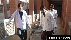 Pakistani paramedics carry an injured bomb blast victim to a hospital after the bombing at a market in the northwestern district of Orakzai.