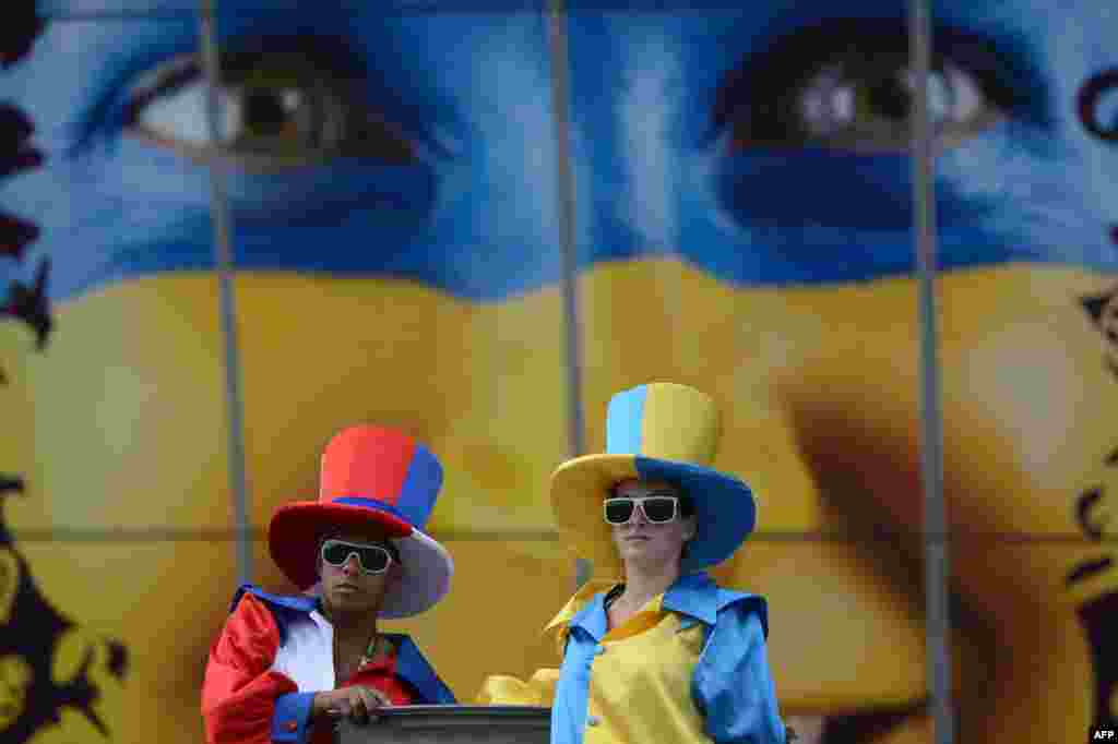 Stilt walkers dressed in the colors of Ukraine and France pose in front of the Donbass Arena ahead of the Euro 2012 match Ukraine and France in Donetsk. (AFP)