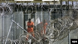 Dressed in orange coveralls, alleged al-Qaida and Taliban combatants captured in Afghanistan wash before midday prayers at Camp X-Ray at the US Naval Base at Guantanamo Bay, Cuba (File photo, 2002).