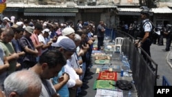 Palestinian Muslim worshippers pray outside Damascus Gate in Jerusalem's Old City on July 21.