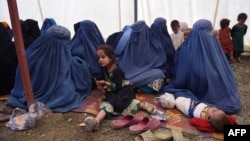 Afghan women sit with their children after returning to Afghanistan from Pakistan in September 2016.|