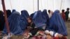 Afghan refugees sit with their children after returning to Afghanistan from Pakistan in a camp on the outskirts of Kabul. (file photo)