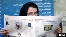 Iran -- Tehran, An Iranian woman reads a newspaper in 15th press festival in Tehran.