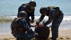 Militari ucraineni dezamorsează o mină anti-navă adusă la țărm de o furtună, în contextul invaziei ruse în Ucraina, 16 mai 2022.