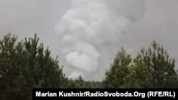 Дым после мощного взрыва на складе боеприпасов военной базы недалеко от города Ичня в 170 км (110 миль) к востоку от Киева, 9 октября 2018 года.