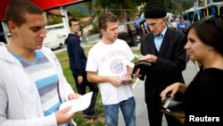 Volunteers hand out leaflets with information about new Bosnia's census in Jablanica, 60 kilometers south of Sarajevo, in September 2013.