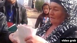 Një grua duke votuar në emër të anëtarëve të familjes, Taxhikistan, 6 nëntor 2013