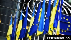 Ukrainian and European Union flags hang together outside the European Parliament in Brussels.