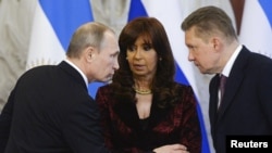 Russian President Vladimir Putin (left) with Argentinian President Cristina Fernandez (center) and Gazprom Chief Executive Officer Alexei Miller at a signing ceremony for energy deals in the Kremlin, Moscow, on April 23.