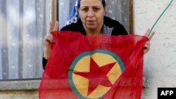 Архивска фотографија: Курдка со знамето на ПКК во турскиот град Дијарбакир во 2009 година