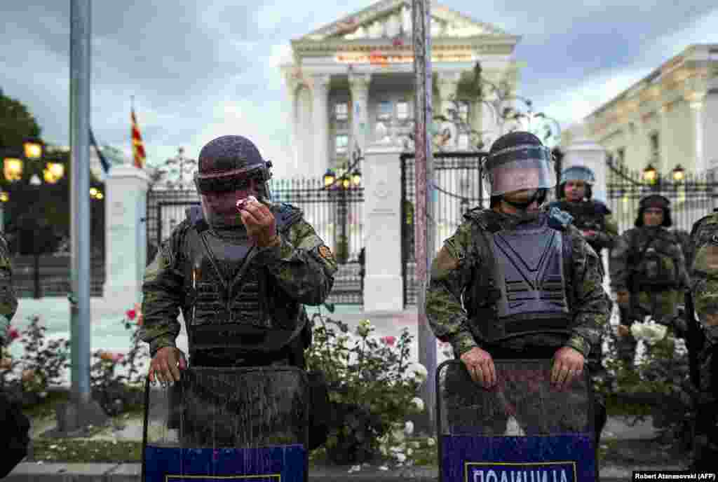 A police officer tries to remove red paint from his helmet's visor after protesters threw balloons filled with colored paint during an antigovernment protest in Skopje, Macedonia. (AFP/Robert Atanasovski)