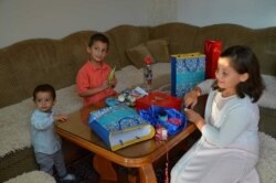 Safijina djeca otvaraju poklone na Bajram.