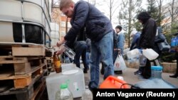 Oamenii se înghesuie să ia dezinfectant distribuit gratuit ca măsură de prevenție împotriva epidemiei de coronavirus, Sankt Petersburg, 26 martie 2020
