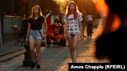 Young women stroll through a park in Tashkent in August 2018. 