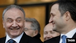 Newly elected President Nicolae Timofti (left) smiles at Prime Minister Vlad Filat during a parliament session in Chisinau on March 16.