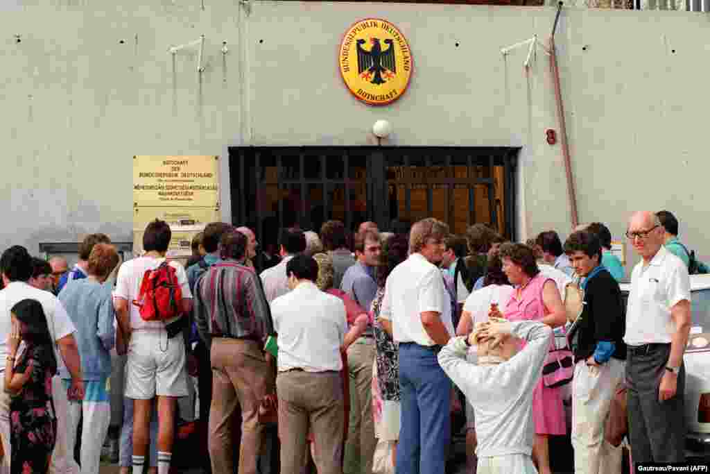 Немцы из Восточной Германии ждут виз перед консульством ФРГ в Будапеште. 14 августа 1989 года.