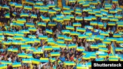 (©Shutterstock) Українські вболівальники підтримують свою команду під час кваліфікаційного матчу «Євро-2016» між Україною та Македонією на стадіоні «Арена Львів». Львів, 12 жовтня 2014 року