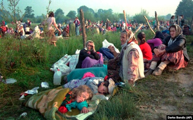 Izbjeglice iz sigurne zone Srebrenica, koje su provele noć na otvorenom, ispred američke baze na aerodromu u Tuzli, 14. juli 1995.