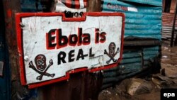 Информационная табличка в трущобах Монровии, столицы Либерии. "Эбола существует!"