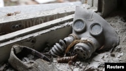 Жас баланың газтұтқысы мен аяқ киімі. Чернобыль атом электр станциясы маңындағы иен қалған Припять қаласы. 4 сәуір 2011 жыл.