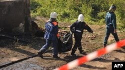 Russian rescue workers remove a body bag at the site of a deadly fire that razed a psychiatric hospital in Novgorod Oblast, killing at least 37 people.
