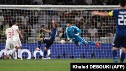 Japanese forward Yuya Osako (center) heads the ball home to score a controversial opening goal in the Asian Cup semifinal against Iran in Abu Dhabi on January 28.