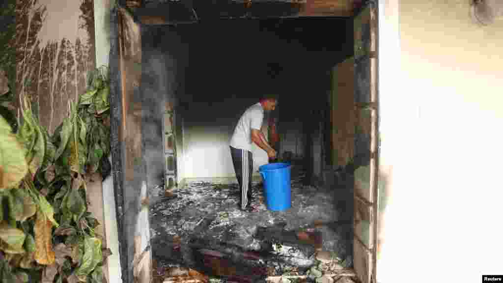 A man stands inside the U.S. Consulate, which was attacked and set on fire by gunmen.
