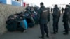 Russian police detain migrant workers during a raid on the Pokrovsky vegetable storage depot in the Biryulyovo district of Moscow on October 14, one day after the rioting sparked by the killing.