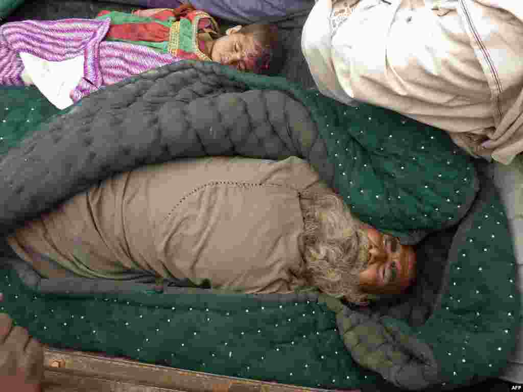 The bodies of an elderly Afghan man and a child are pictured in the village of Alkozai in Kandahar Province on March 11. An AFP reporter counted 16 bodies -- including women and children -- in three Afghan houses after a U.S. soldier walked off his base and began shooting civilians. NATO's International Security Assistance Force said it had arrested a soldier "in connection to an incident that resulted in Afghan casualties in Kandahar province," without giving a figure for the dead or wounded. (AFP/ Mamoon Durrani)