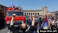 ARMENIA -- Supporters of opposition lawmaker Nikol Pashinian react standing on top of a vehicle as they protest in Republic Square in Yerevan on Wednesday, May 2, 2018.