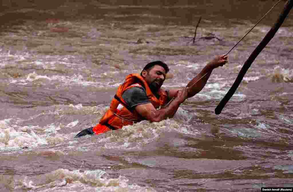 A State Disaster Response Force member searches for a man who drowned during flash floods in Tailbal on the outskirts of Srinagar, India. (Reuters/Danish Ismail)