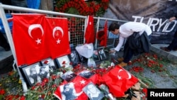 A man places flowers at the entrance to the Reina nightclub in Istanbul on January 3, 2017.