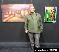 Мацей Басаў каля сваіх карцін «Шлях сьвятла» і «А як жа я?»