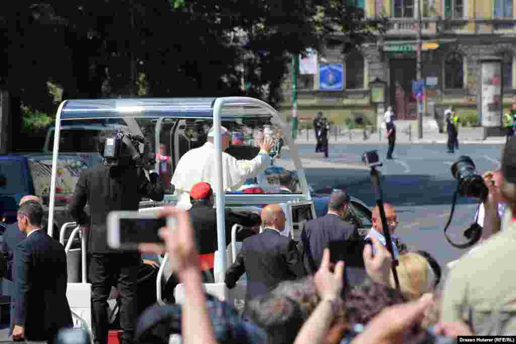 Papa Franjo pozdravlja okupljene građane iz papamobila na putu do stadiona Koševo.