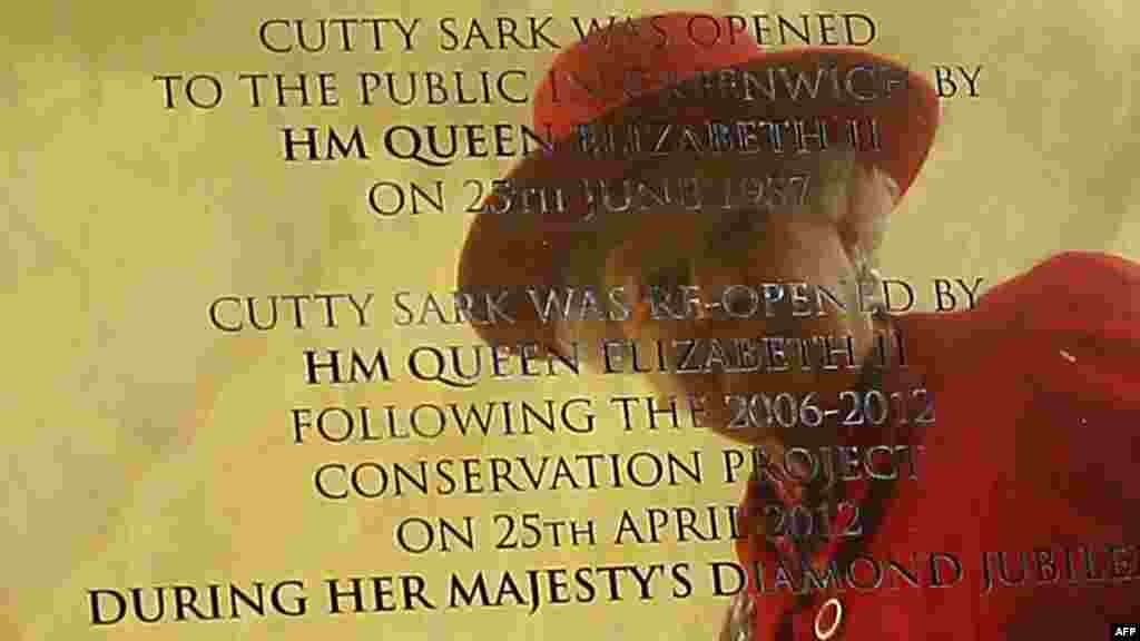 Queen Elizabeth II is reflected in a plaque during a visit to reopen the &quot;Cutty Sark&quot; tea clipper in Greenwich, east London, on April 25. (AFP/Kirsty Wigglesworth)