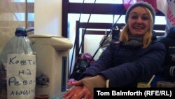 A volunteer hands out tea and coffee in the foyer of the City Council building. 