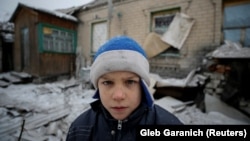 Мальчик на фоне разрушенного в результате обстрелов дома. Авдеевка, 2 февраля 2017 года