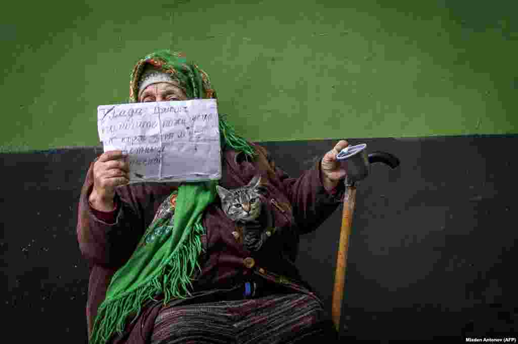 An elderly woman begs for money for food and for treatment for her cat on a street in downtown Moscow. (AFP/Mladen Antonov)