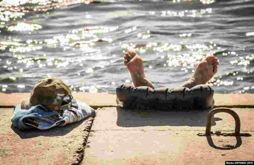 A man sunbathes on the bank of the Volga River in Volgograd, Russia. (AFP/Mladen Antonov)