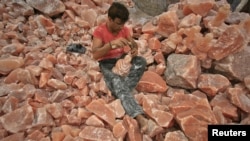 A man applies the final touches to a sculpture made from Himalayan pink rock salt on the outskirts of Lahore.