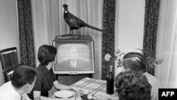 Парижская семья смотрит по телевизору выступление президента де Голля, 1961