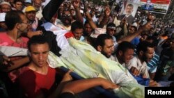 Прихильники Мухаммада Мурсі несуть тіло вбитого товариша під час стрілянини біля штаб-квартири Республіканської гвардії в Каїрі, 8 липня 2013 року