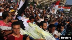 Сторонники Мохаммеда Мурси несут тело погибшего в столкновениях у здания Республиканской гвардии