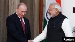 Russian President Vladimir Putin (left) shakes hands with Indian Prime Minister Narendra Modi during a photo opportunity ahead of their meeting at Hyderabad House in New Delhi on December 11.