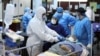 Emergency medical staff and nurses wearing protective suits, help while transferring a patient with coronavirus disease (COVID-19) to Masih Daneshvari Hospital, in Tehran, March 30, 2020